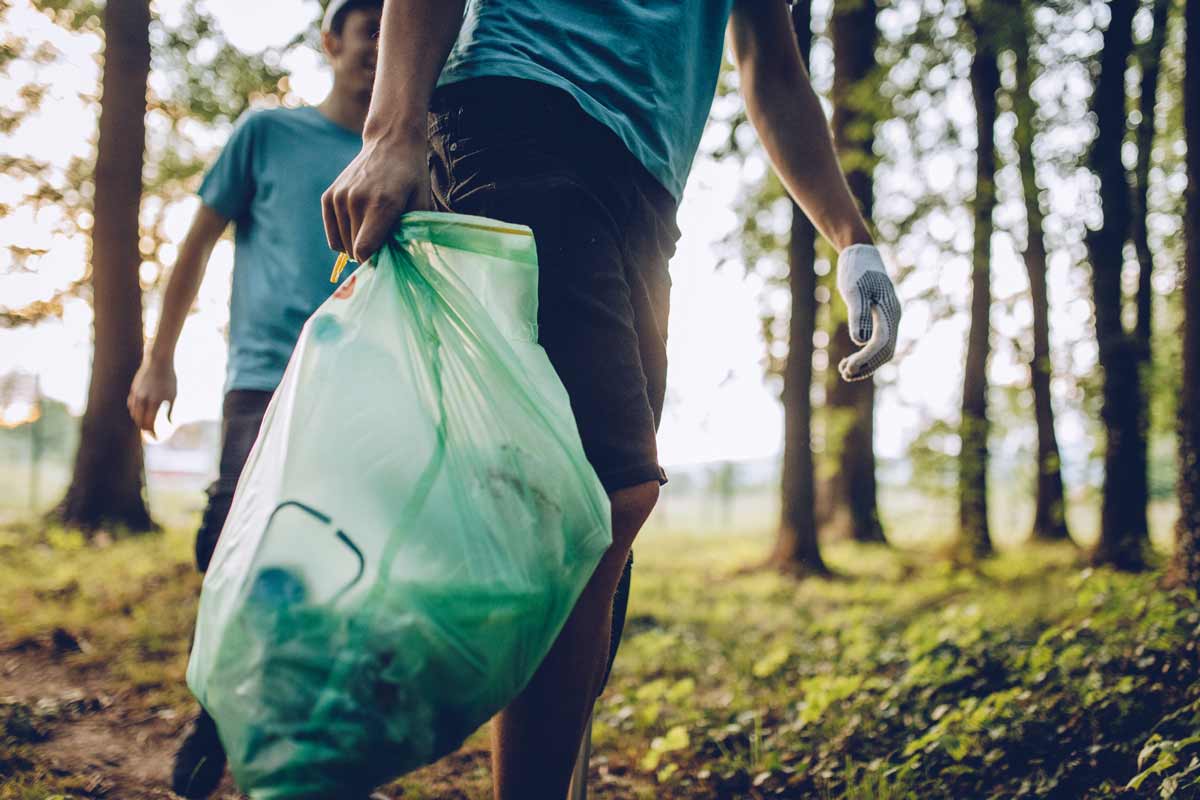 Groupe de collecte qui ramasse des dÃ©chets abandonnÃ©s dans la forÃªt.